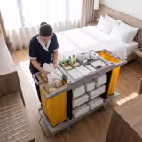 Carrello di servizio - aperto - 3 ripiani a vassoio con bordo, piano superiore con 8 scomparti per amenities, 2 sacchi biancheria, ruote 2 con freno